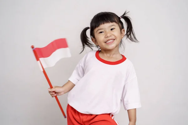 Indonesische Kid glimlachend naar camera met vlag — Stockfoto