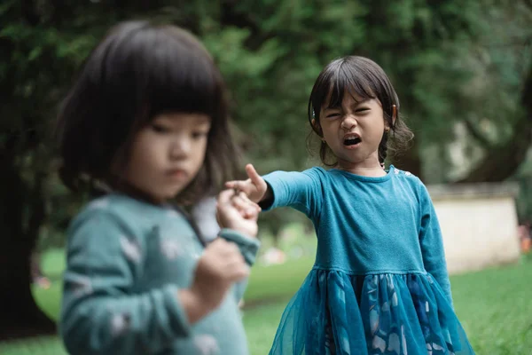 Две маленькие девочки дерутся из-за игрушек — стоковое фото