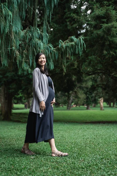 Pregnant asian young woman walking in the park — Stock Photo, Image