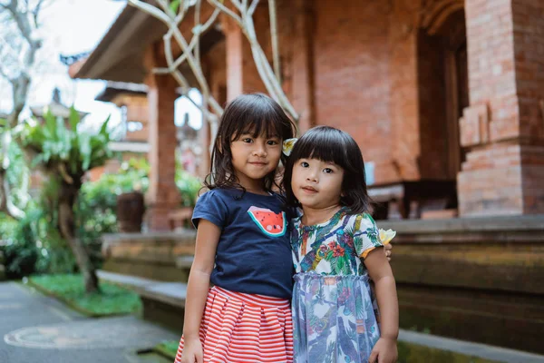 Δύο όμορφο κορίτσι στέκεται μπροστά από το παραδοσιακό σπίτι — Φωτογραφία Αρχείου