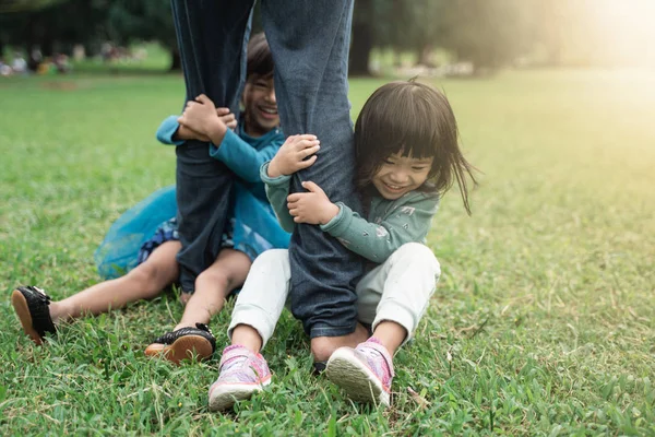 two little girl holding foot her father