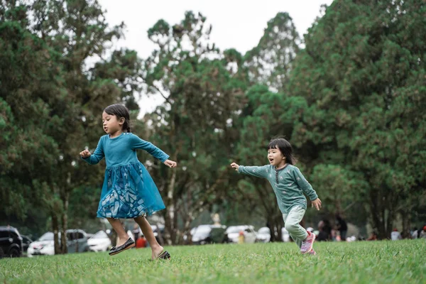 Dos niñas jugando perseguirse entre sí — Foto de Stock