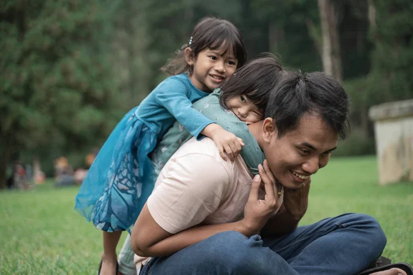 Dos niña abrazando a su padre — Foto de Stock