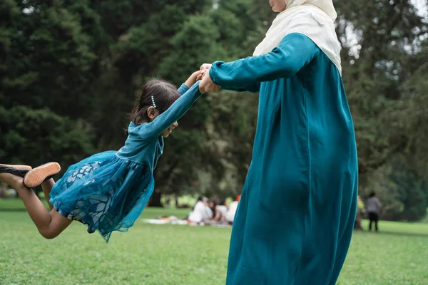 Mother holding her daughter and spin around happily