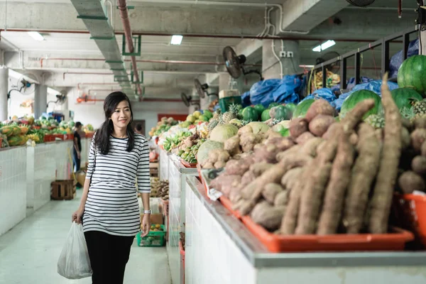怀孕的亚洲年轻女子站在携带塑料袋 — 图库照片