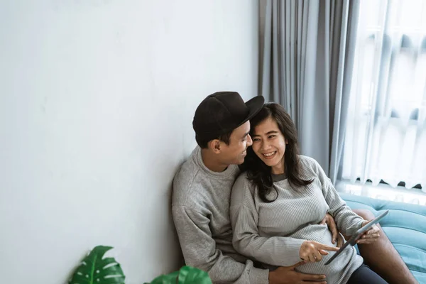 Marido y mujer utilizan pestañas para ver la información sobre el embarazo — Foto de Stock