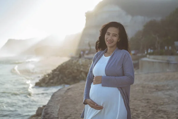 Pregnant mother stands next to a cliff — Stock Photo, Image