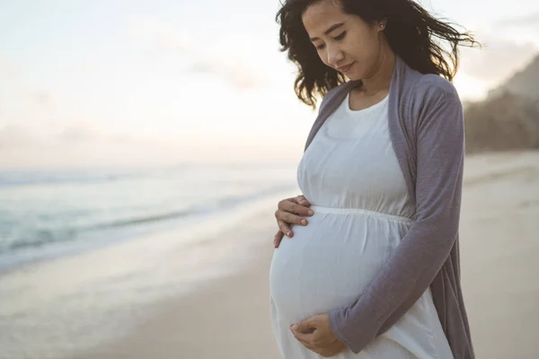 Besorgte Schwangere steht am Strand — Stockfoto