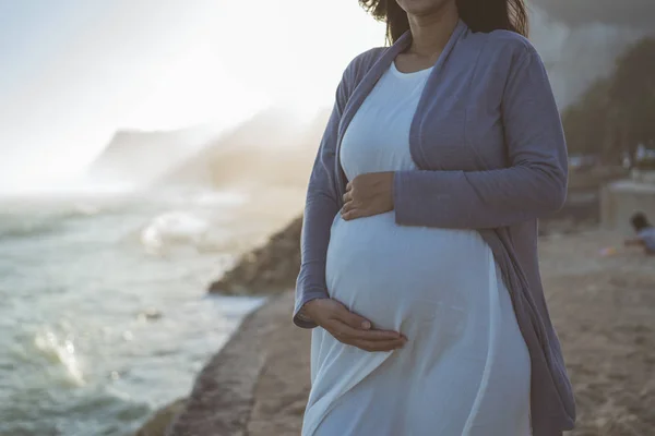 Красивая беременная женщина стоит на пляже — стоковое фото