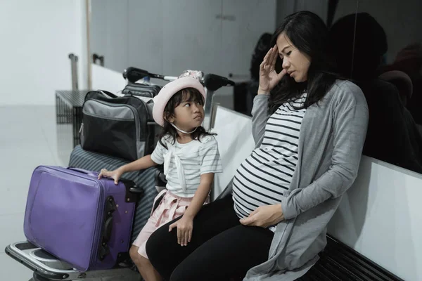 Grávida asiático mulher sentir tonto e sua filha quando no espera quarto aeroporto — Fotografia de Stock