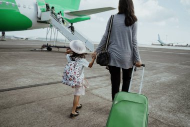 bir anne ve kızı bir bavul ile yürümek eller katılmak