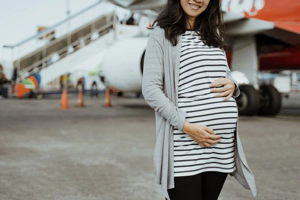 Aziatische zwangere vrouwen staan naast een koffers op de landingsbaan — Stockfoto