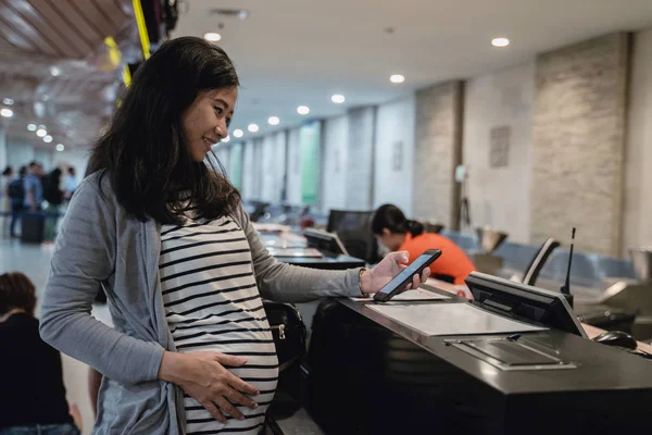 Embarazada asiático mujer uso smartphones para ticket confirmación — Foto de Stock