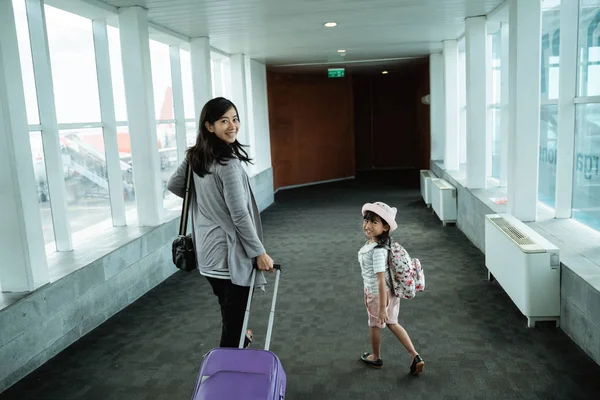 Een Aziatische moeder en haar dochter liep omhoog en trok een koffer — Stockfoto