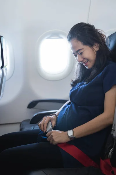 Счастливая беременная мать наслаждается безопасным полётом — стоковое фото