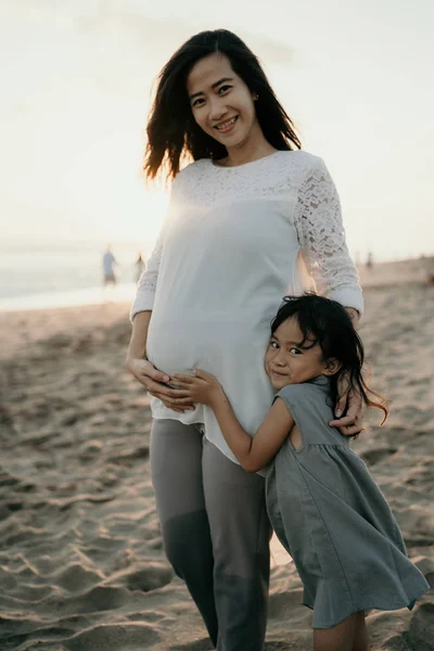 Έγκυες γυναίκες και οι κόρες τους στέκονται στην παραλία — Φωτογραφία Αρχείου