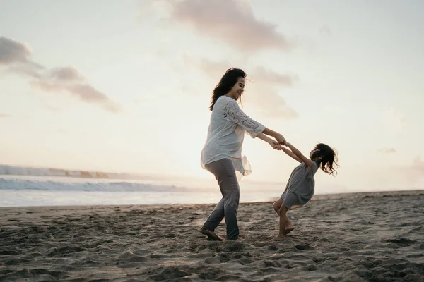 Jovem mãe brincando com sua menina junto ao mar — Fotografia de Stock