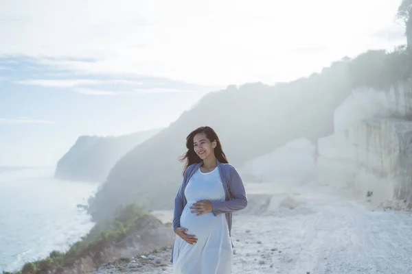 Incinta madre si trova accanto a una scogliera — Foto Stock