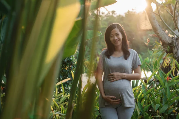 Zwangere jonge moeder staand met handen Hold — Stockfoto