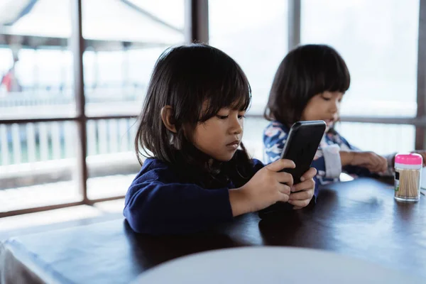Little girl enjoy playing games using smartphone — Stock Photo, Image