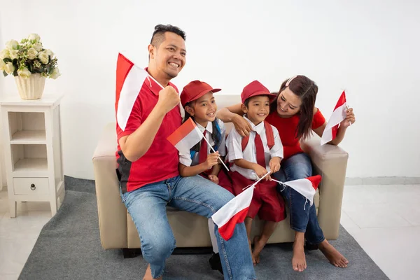 Keluarga indonesia memegang bendera indonesia di atas latar belakang putih — Stok Foto