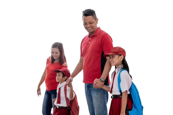 Elementary students and parent walking together to school — Stock Photo, Image