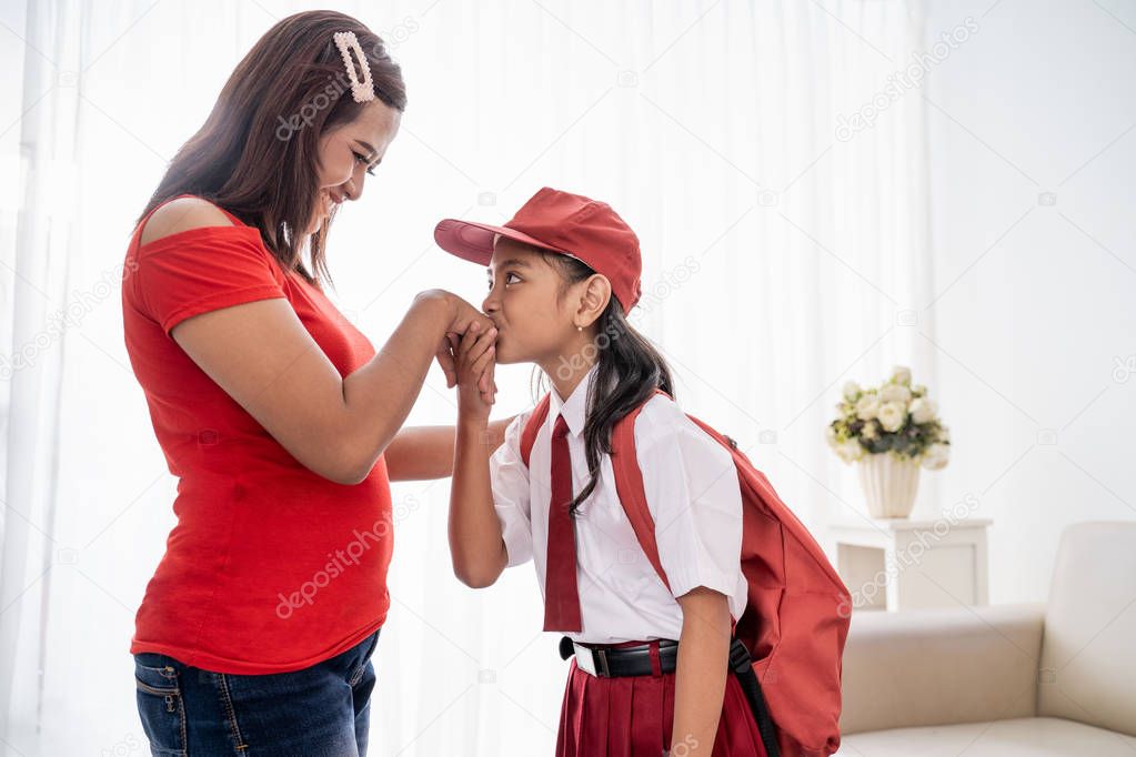 kid kissing mothers hand while shaking hand