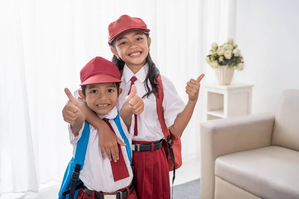 Primary student wearing school uniform showing thumbs up — Stock Photo, Image