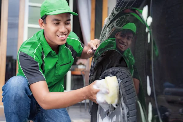 Masculino no uniforme limpeza seus clientes carro — Fotografia de Stock
