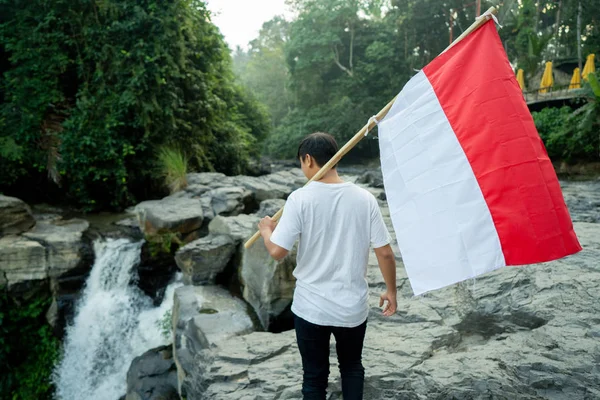 Uomo con bandiera indonesiana dell'indonesia in cima alla montagna — Foto Stock