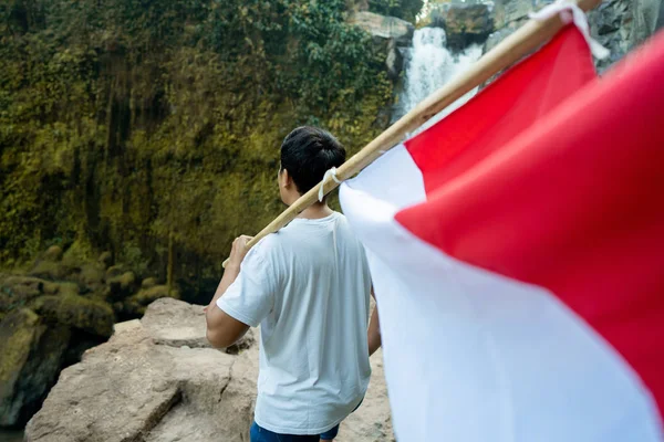 산 꼭대기에 인도네시아의 인도네시아 국기를 가진 남자 — 스톡 사진