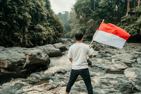 Mężczyzna z indonezyjskiej flagi Indonezji na szczycie góry — Zdjęcie stockowe