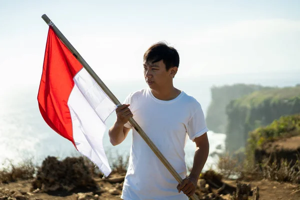 Uomo con bandiera indonesiana dell'indonesia in cima alla montagna — Foto Stock