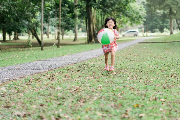 Kislány játszik ballonnal labdát a parkban — Stock Fotó