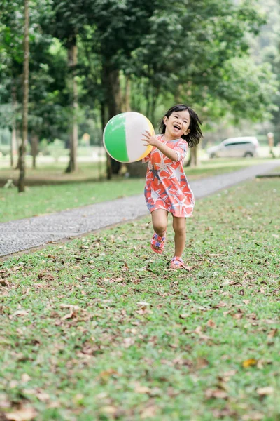 Aziatische schattig meisje geniet van het spelen alleen in de tuin — Stockfoto