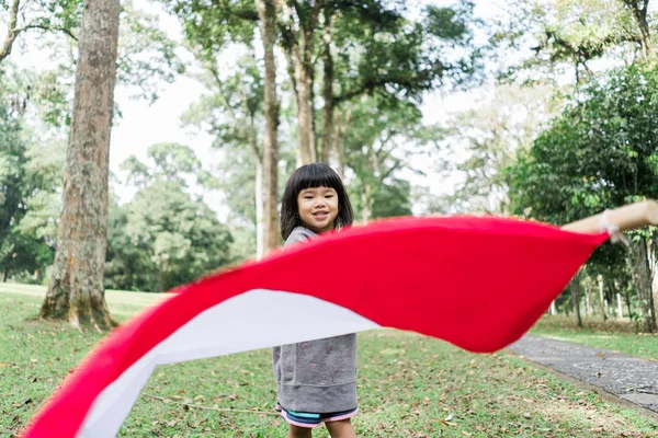 Asiatiskapojke liten flicka flaxande indonesiska flagga — Stockfoto