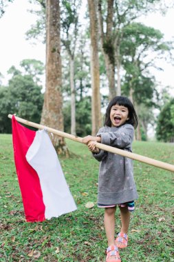Küçük kız gurur mutluluk ile Endonezya bayrağı çırpan