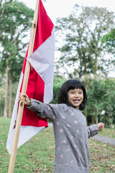 Asiatiskapojke liten flicka flaxande indonesiska flagga — Stockfoto