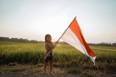 Küçük kız gurur mutluluk ile Endonezya bayrağı çırpan
