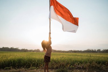 Küçük kız gurur mutluluk ile Endonezya bayrağı çırpan