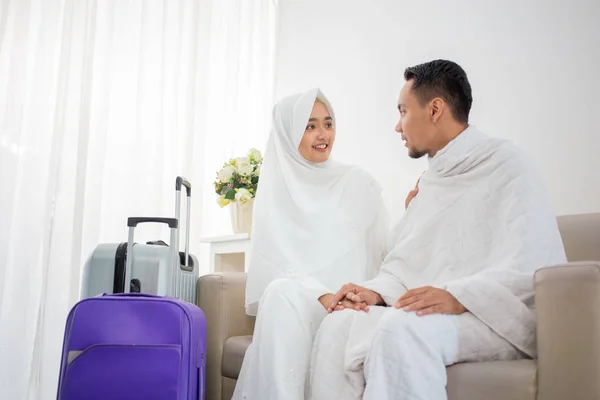 Pasangan muslim duduk mengenakan pakaian tradisional putih sebelum umrah — Stok Foto