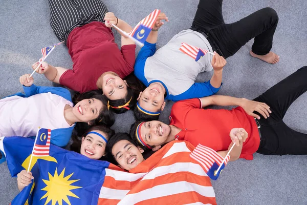 Ενθουσιασμένοι νεαρός ασιάτης υποστηρικτής κρατώντας μαλαισία σημαία — Φωτογραφία Αρχείου