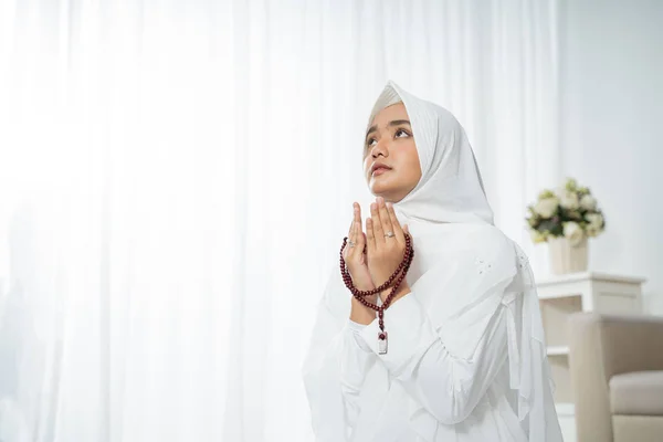 Junge muslimische Frau betet in weißer traditioneller Kleidung — Stockfoto