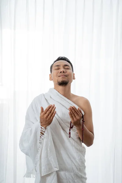 Muslim young man praying using tasbih — Stock Photo, Image