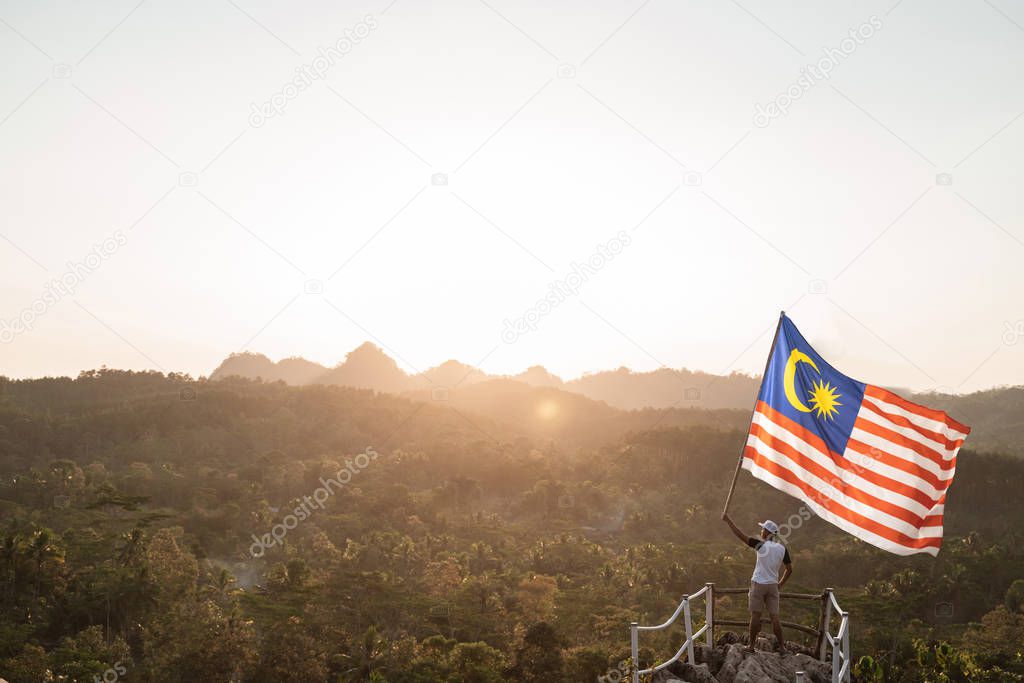 asian male with malaysian flag celebrating independence day
