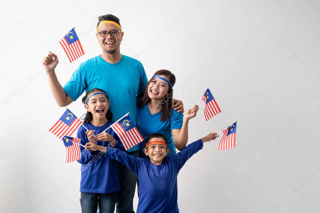 malaysian family holding malaysia flag over white background