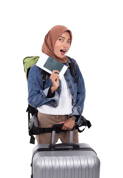 Asiático hijab mulher animado segurando bilhete e passaporte de pé perto mala e saco de transporte — Fotografia de Stock