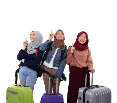 Üç hijab kadın bavul tutan ve elleri işaret çanta taşıyan ayakta