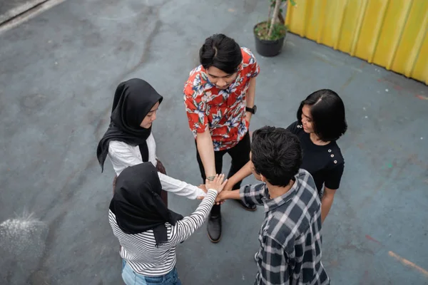 Unga människor att sätta händerna ihop — Stockfoto