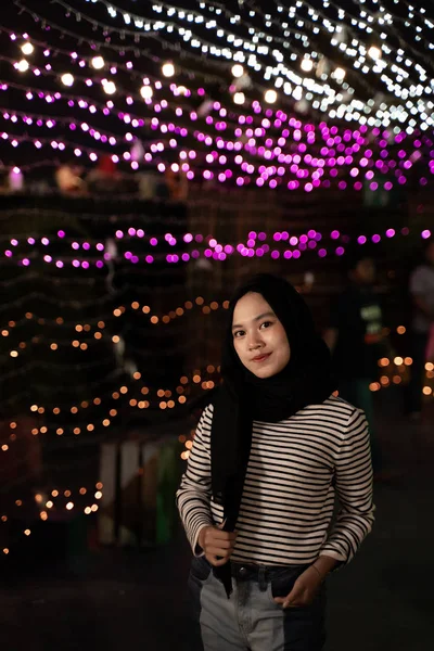 Zahalená žena stojící v blízkosti lampy — Stock fotografie